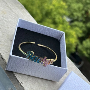 Colorful stainless steel gold nameplate bangles with custom kid's name necklace set by Hot Trend Vault, featuring vibrant and shiny jewelry.