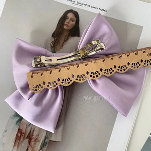 Elegant satin bow barrette hair clip with oversized knot design for women, from Hot Trend Vault, styled on a model.