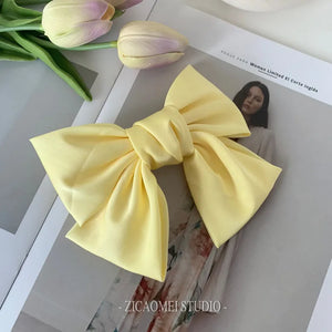 Satin bow barrette hair clip for women with oversized knot design, elegant hair accessory by Hot Trend Vault.