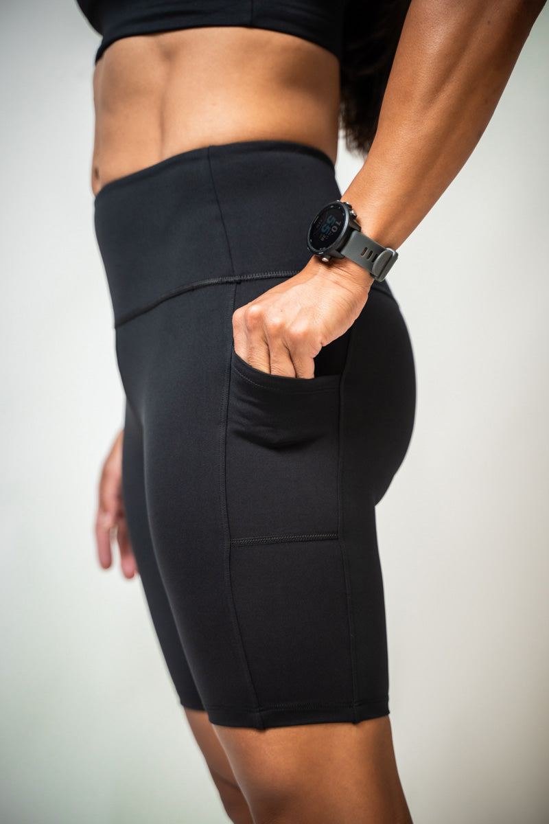 Black SOHO Women's Technical High Rise Shorts with 8-inch inseam, shown on a model, highlighting their sleek fit and sporty design.