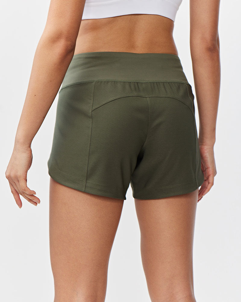 Back view of Hot Trend Vault Excel Women's Workout Shorts in dark moss, designed for extra coverage during sprints.