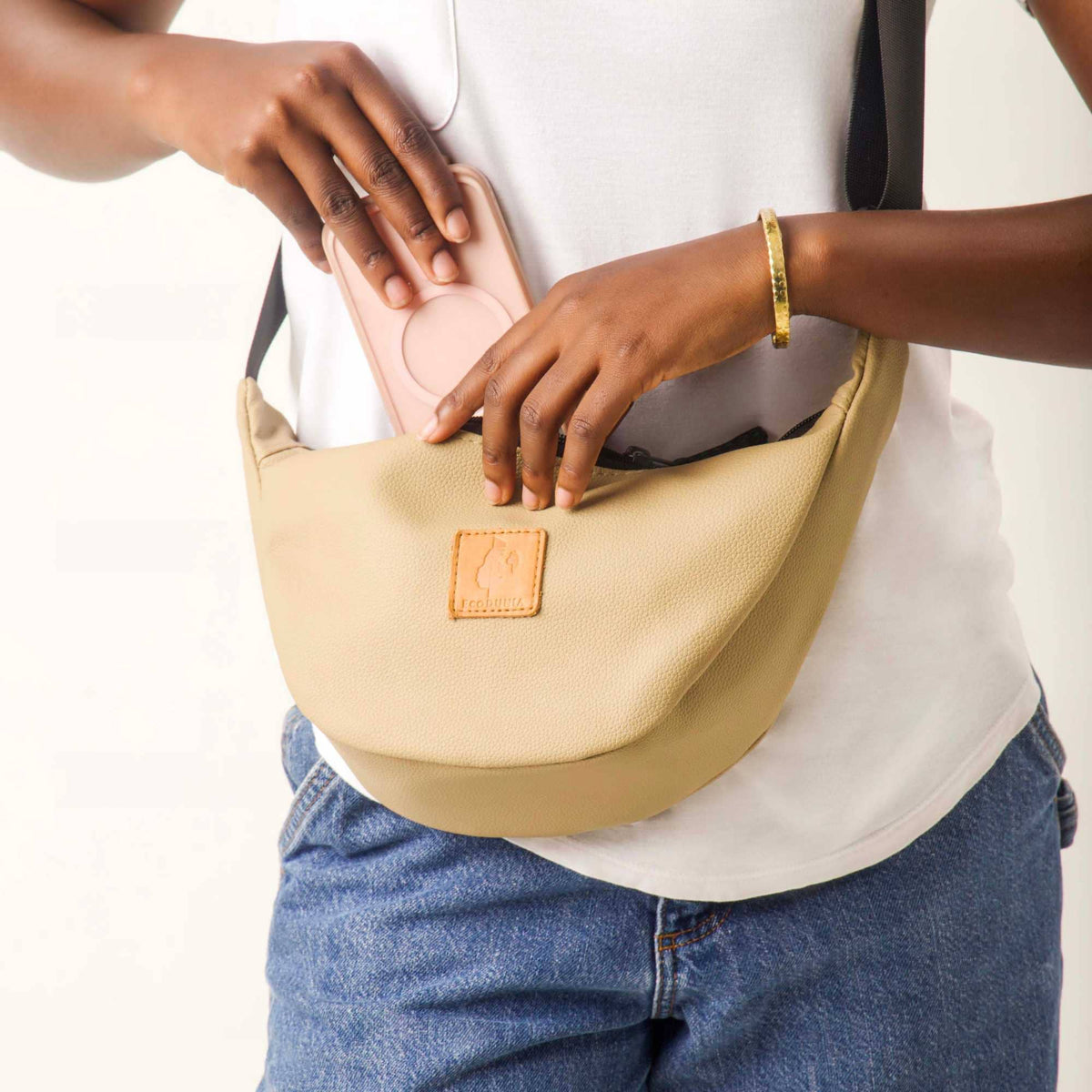 Round mini vegan leather shoulder bag by Ecodunia with Kenyan fabric lining, featuring a latte-colored, compact, stylish design.