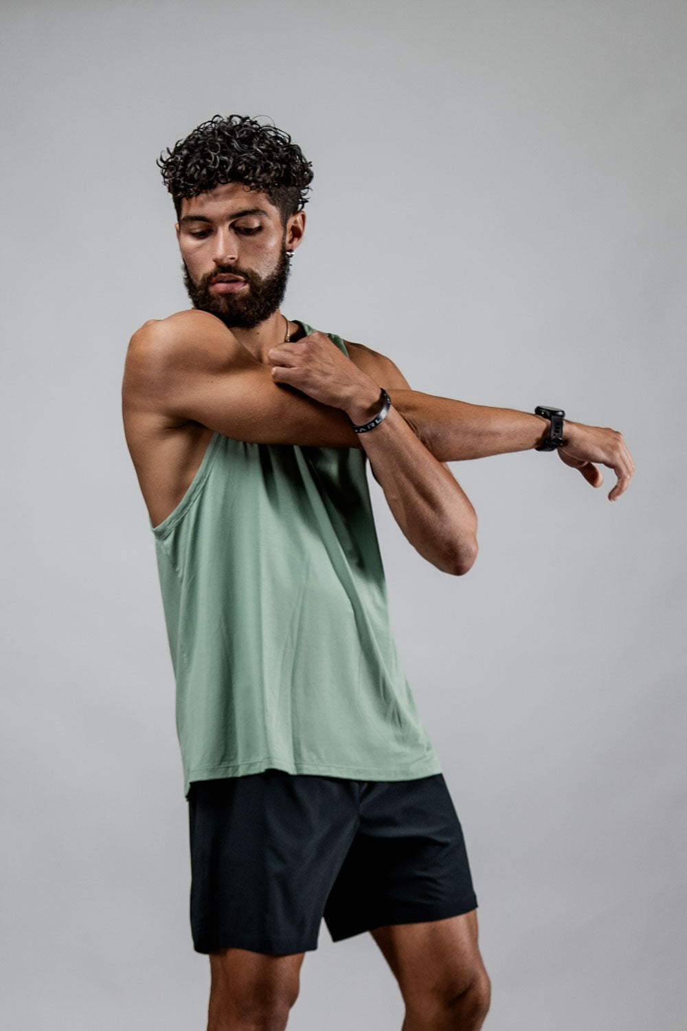 Men's olive green Terra Recovery Tank top by Hot Trend Vault, shown in a low light setting, ideal for everyday movement.
