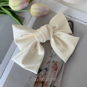 Elegant satin bow barrette hair clip with oversized knot design, ideal for women’s stylish hair accessories.