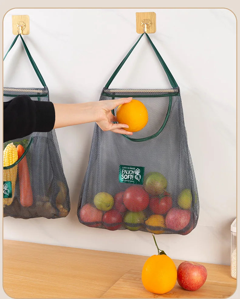 Reusable mesh storage bags hanging in a kitchen, used for storing vegetables, from Hot Trend Vault.