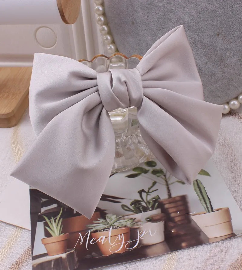 Oversized satin bow knot hair clip for women, elegant barrette accessory by Hot Trend Vault, shown on smooth hair.