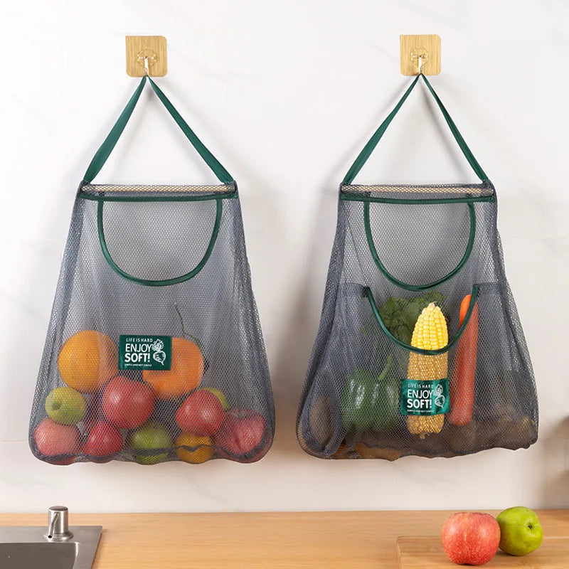 Reusable mesh storage bags hanging in a kitchen, designed for storing vegetables, from Hot Trend Vault.