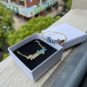 Colorful stainless steel gold nameplate bangles with custom kid's name necklace set from Hot Trend Vault, featuring vibrant, shiny jewelry.