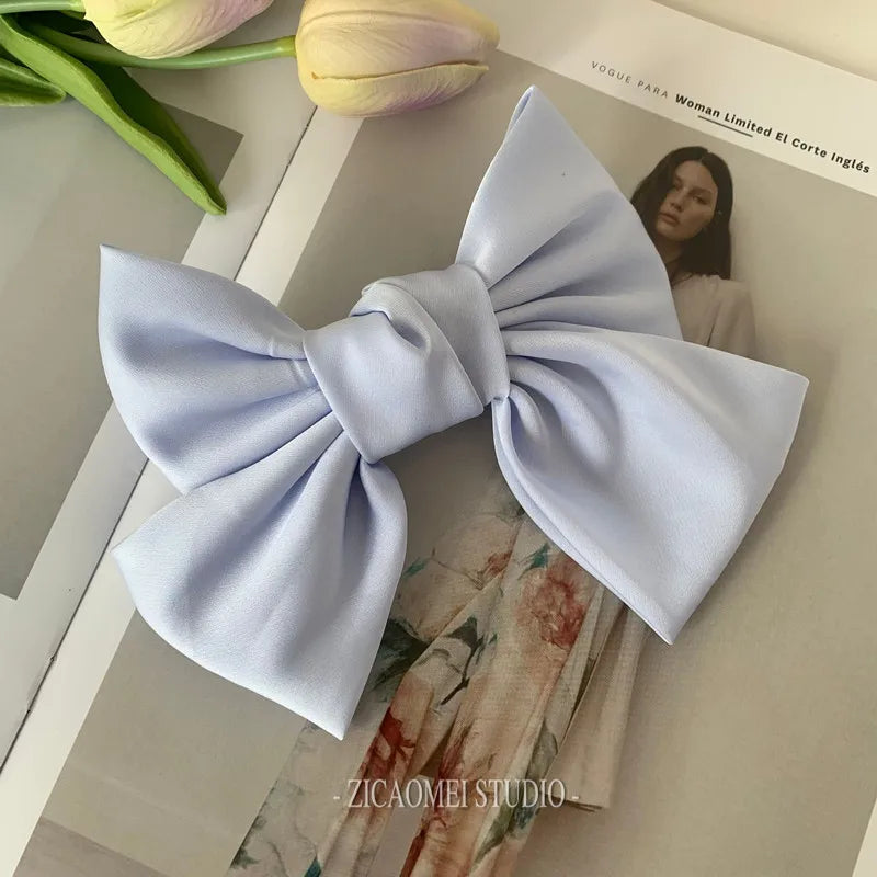 Elegant satin bow barrette hair clip for women featuring an oversized knot design, perfect for stylish hair accessories.