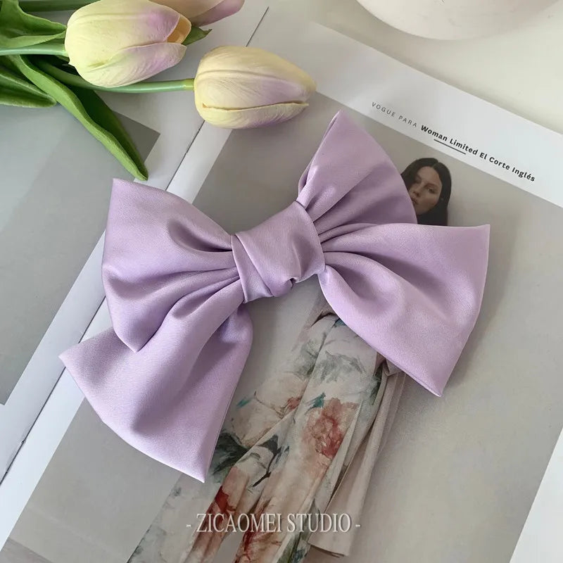 Elegant satin bow barrette hair clip with oversized knot design, perfect for women's stylish hair accessories.