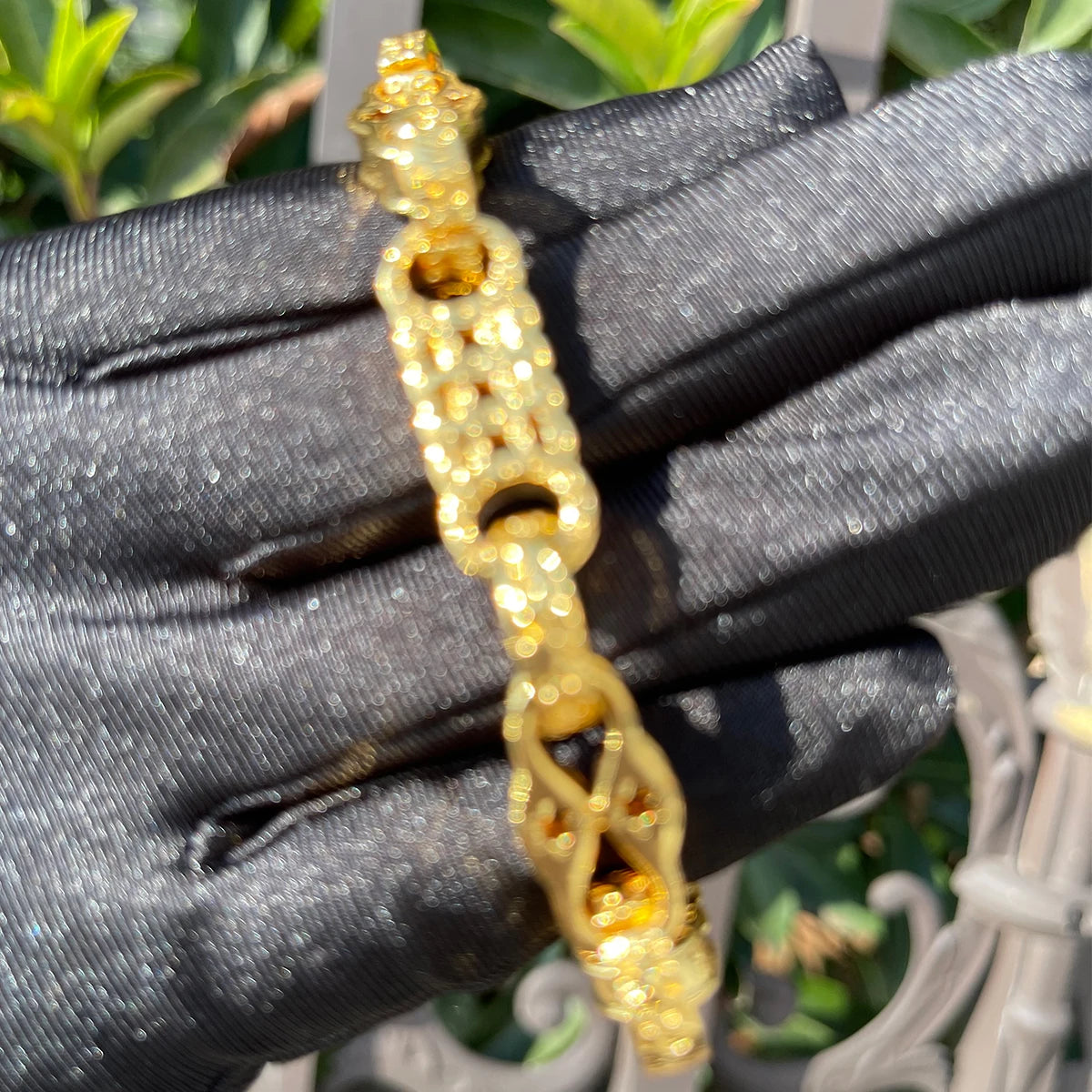 Gold plated bubble letter bracelet for men with iced out jewelry design, showcasing bold, shiny accessory on a neutral background