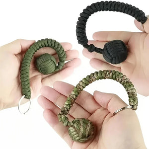 Outdoor self-defense umbrella rope kit with monkey fist steel ball and paracord key chain, designed for outdoor enthusiasts.