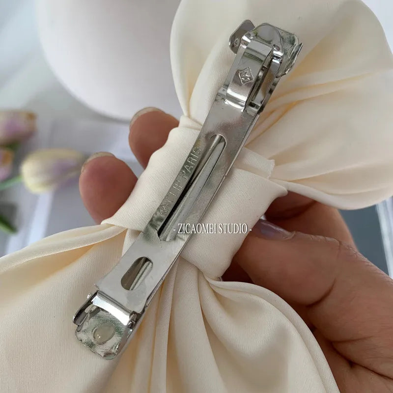 Elegant satin bow barrette hair clip for women with oversized knot design, from Hot Trend Vault, perfect for sophisticated hairstyles.