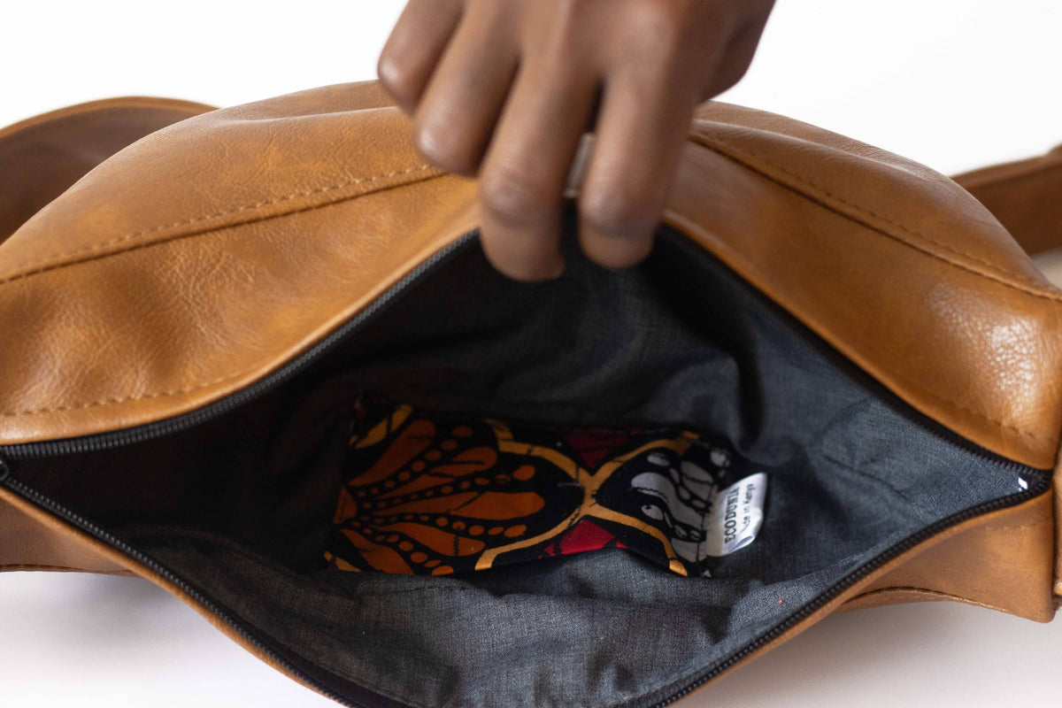 Brown round vegan leather mini shoulder bag with Kenyan fabric lining, stylish Ecodunia crossbody bag for everyday use.
