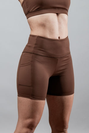 Women’s SOHO 5-inch inseam fitness shorts in city mocha by Hot Trend Vault, shown on a woman’s lower body with side view.