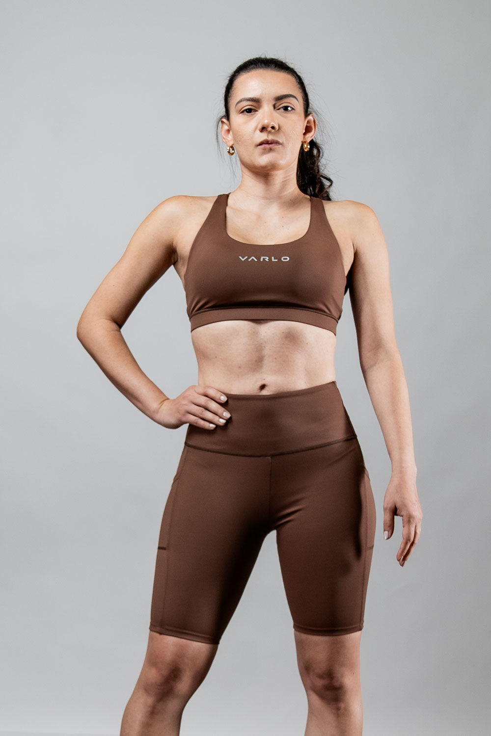 Women wearing Hot Trend Vault SOHO Fitness Shorts, 8-inch inseam, in city mocha color, designed for activewear and performance workouts.